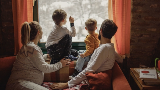 Family looking out the window at snow